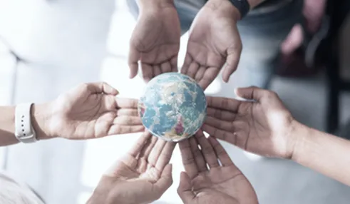 six hands holding a globe