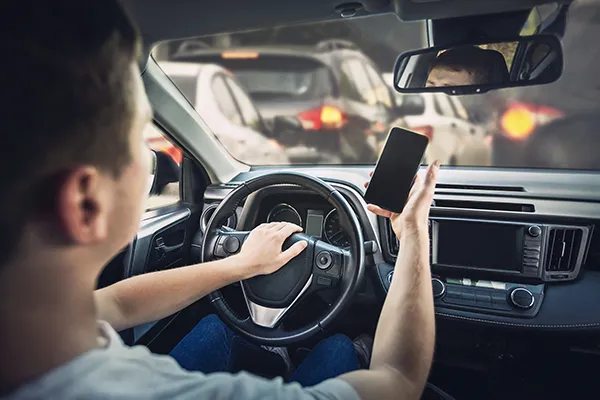 man holding his mobile phone while driving