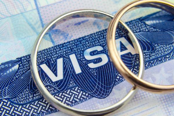 Macro photo of US entry visa sticker in a passport and a couple of rings.